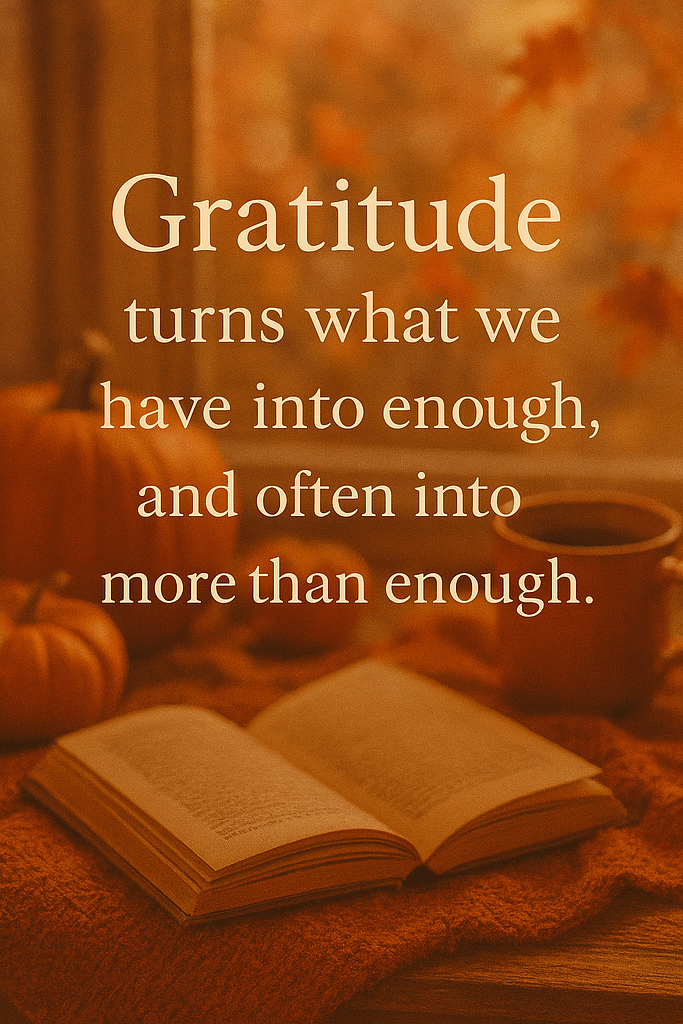A warm, cozy autumn scene featuring an inspirational quote in elegant serif font: “Gratitude turns what we have into enough, and often into more than enough.” The background includes a soft orange knitted blanket, an open book with slightly yellowed pages, and two pumpkins—one large and one small—resting nearby. A ceramic mug filled with a dark beverage sits to the right. Behind the objects, a softly blurred window reveals glowing orange and red autumn leaves bathed in golden light, creating a peaceful, homy fall atmosphere.